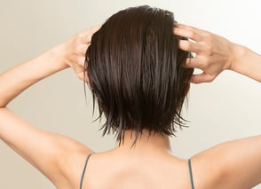 洗い流さないトリートメントを塗布している女性